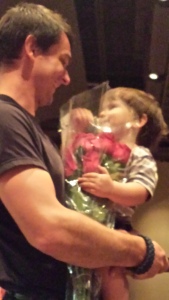 Liam with dad at Jennifer's recital, waiting to give her flowers